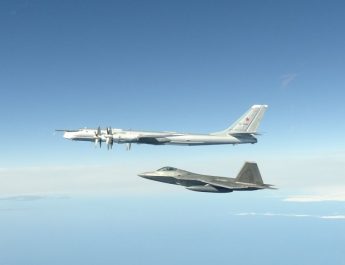 F-22 Raptor flies next to a Russian Tu-95 bomber during an intercept in the Alaskan Air Defense Identification Zone